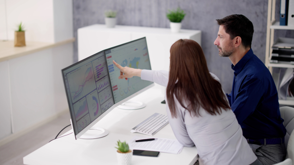 Woman and man sitting at a desk completing data analysis and segmentation