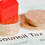 Local Government Mailing: Pound Coins on top of Council Tax Bil with Monopoly Red Hotel piece