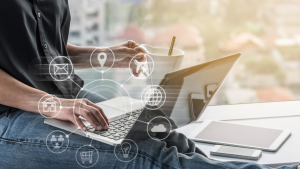 Person sat at laptop holding a cup of coffee with graphic overlaid of digital channels