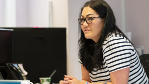 Marian Lively, MD of KPM Group, sitting at desk, leaning forward and listening, ready to help.